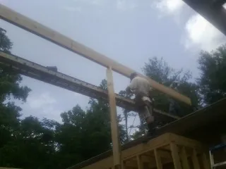 Carpenter setting a ridge beam over a new addition frame — Ice Dam Removal by Roofing Brothers in Fort Ransom