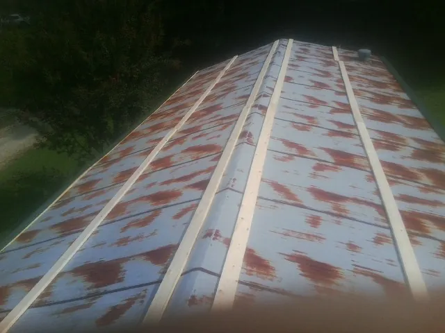 Rusted metal roof panels with new wood purlins before replacement — Storm Damage Roof Repair in Fort Ransom by Roofing Brothers