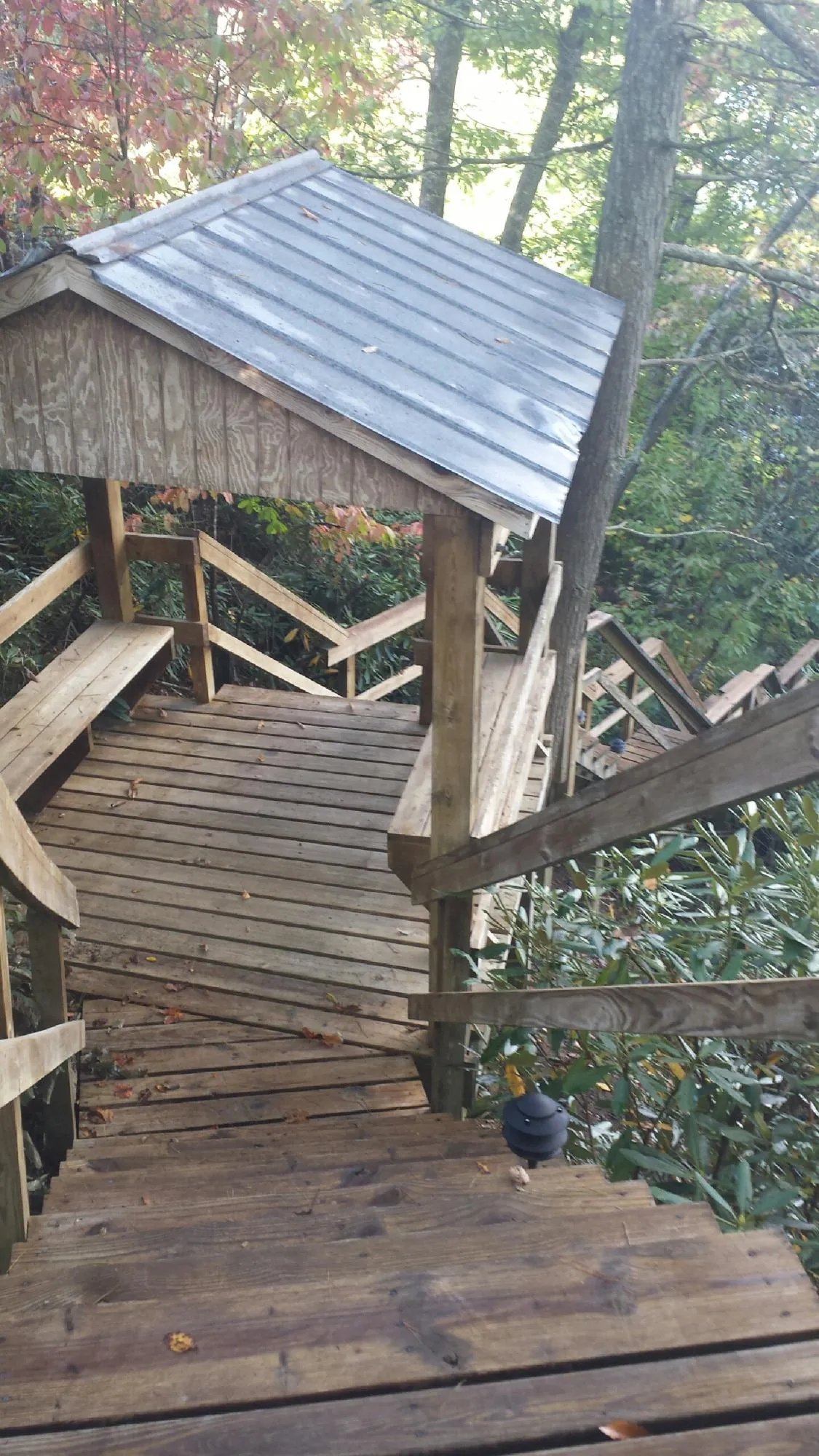 Metal roofed shelter over wooden steps on a wooded walkway — Skylight Repair & Installation work by our crew in Fort Ransom