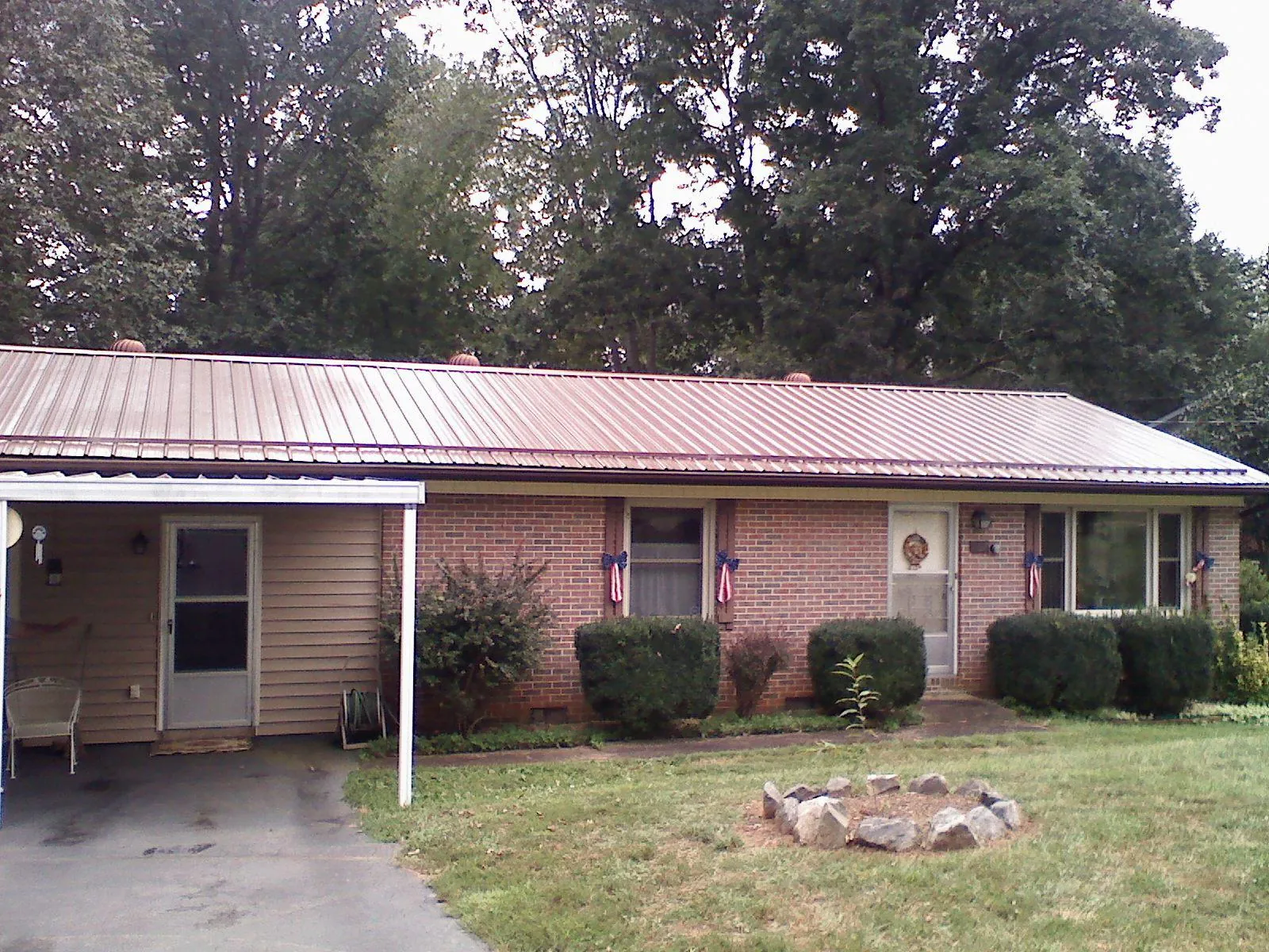 Bronze metal roof and carport on a brick ranch home — Roof Repair work by our crew in Fort Ransom